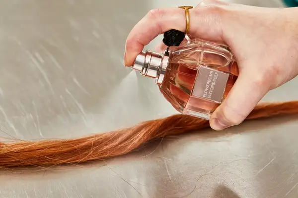 A person sprays hair with Viktor & Rolf Flowerbomb