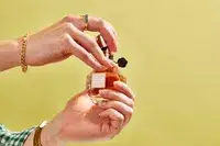 A person removes the cap on a bottle of Viktor & Rolf Flowerbomb