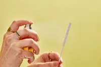 A person sprays Viktor & Rolf Flowerbomb onto a paper test strip