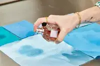 A person sprays fabric with Viktor & Rolf Flowerbomb