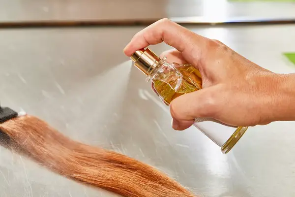 A person sprays Creed Aventus for Her onto hair