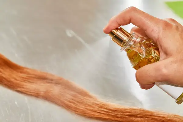 A person sprays hair with Creed Aventus for Her