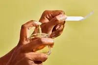 A hand spraying Maison Francis Kurkdjian Baccarat Rouge 540 Eau de Parfum onto a piece of paper