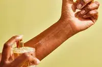 A hand spraying Maison Francis Kurkdjian Baccarat Rouge 540 Eau de Parfum onto their wrist