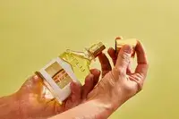 A person removes the cap on the Creed Aventus for Her