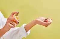 A person sprays AERIN Hibiscus Palm Eau de Parfum onto their wrist