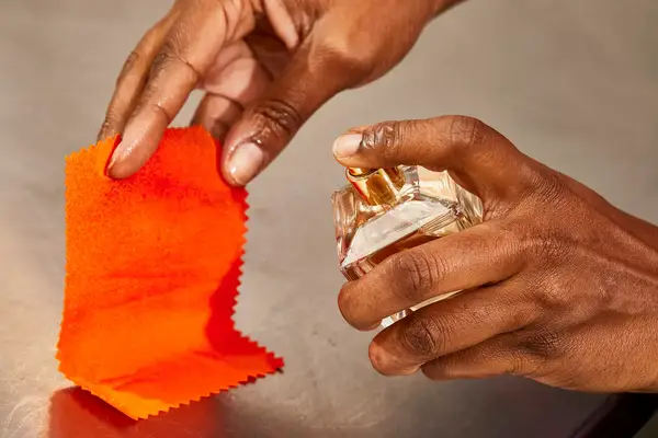 A hand spraying Maison Francis Kurkdjian Baccarat Rouge 540 Eau de Parfum onto fabric