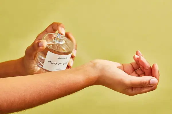 A person sprays Byredo Mojave Ghost onto their arm