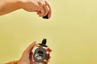 A person removes the cap on the Diptyque Philosykos perfume bottle