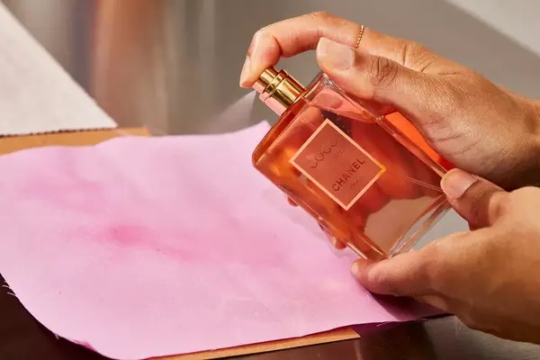 A person sprays fabric with the Chanel Coco Mademoiselle perfume