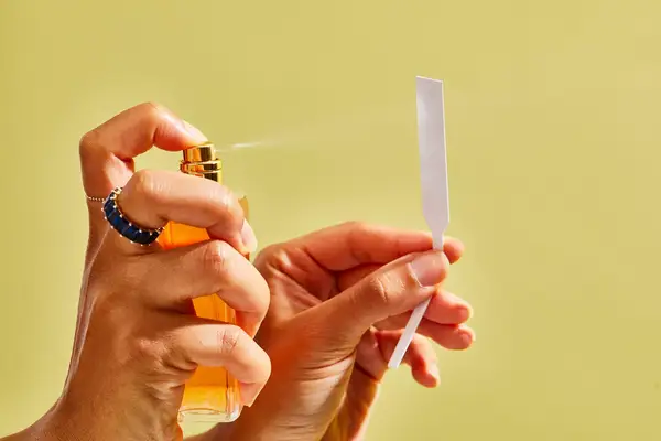 A person sprays Chanel Coco Mademoiselle perfume onto a paper test strip