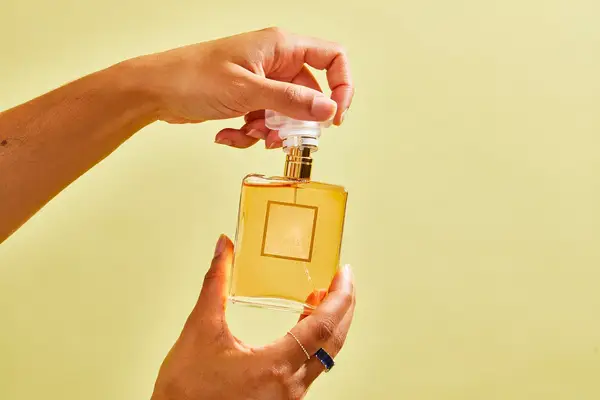 A person removes the cap from the Chanel Coco Mademoiselle perfume