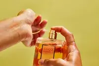 A person sprays Chanel Coco Mademoiselle perfume onto their wrist