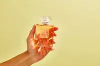 A person holds up a bottle of Chanel Coco Mademoiselle perfume