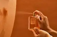 A person sprays fabric with Chanel Coco Mademoiselle perfume