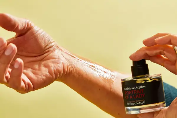 A person sprays FrÃ©dÃ©ric Malle Portrait of a Lady onto their wrist