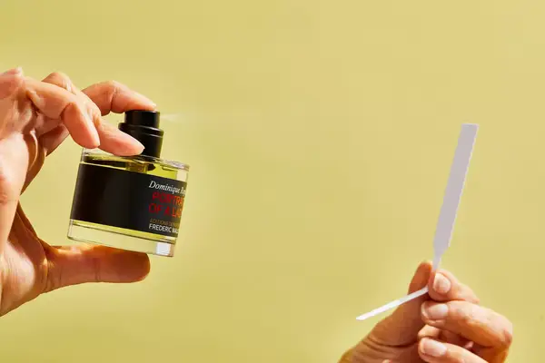 A person sprays a paper test strip with FrÃ©dÃ©ric Malle Portrait of a Lady