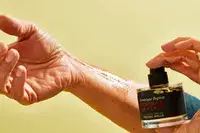 A person sprays FrÃ©dÃ©ric Malle Portrait of a Lady onto their wrist