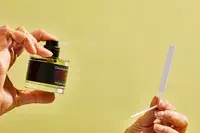 A person sprays a paper test strip with FrÃ©dÃ©ric Malle Portrait of a Lady