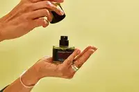 A person places the cap on a bottle of FrÃ©dÃ©ric Malle Portrait of a Lady
