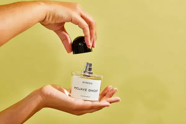 A person holds up a bottle of Byredo Mojave Ghost