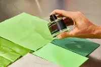 A person sprays FrÃ©dÃ©ric Malle Portrait of a Lady onto fabric