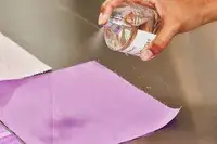 A person sprays Byredo Mojave Ghost onto fabric