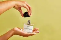 A person holds up a bottle of Byredo Mojave Ghost