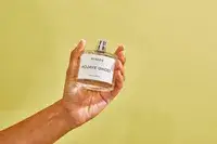 A person holds up a bottle of Byredo Mojave Ghost