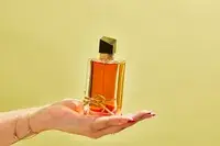 A person holds up a bottle of YSL Libre