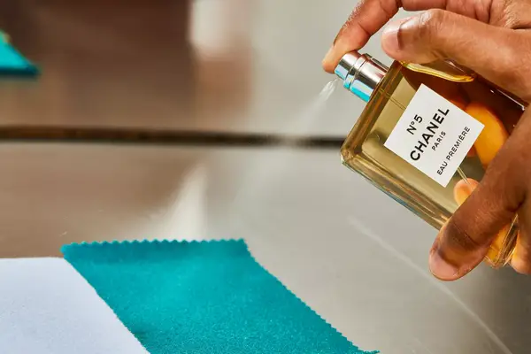 A person sprays fabric with Chanel No. 5 Eau de Parfum