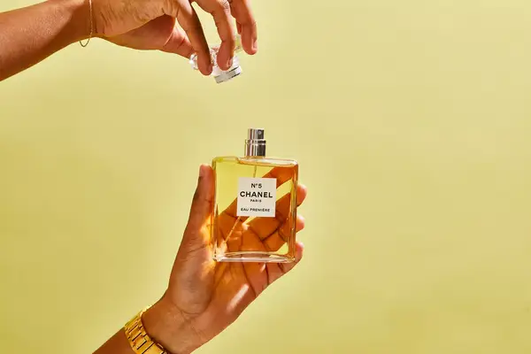 A person removes the cap on a bottle of Chanel No. 5 Eau de Parfum