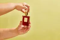 A person removes the top on a bottle of Killian Paris Rolling In Love