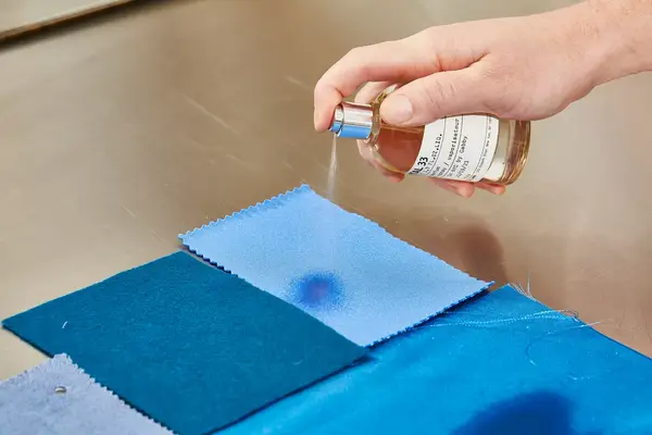 A person sprays Le Labo Santal 33 Eau de Parfum onto fabric