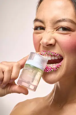 A model takes a bite out of a bottle of Snif Swede Tooth fragrance.