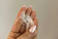 A person shows the color and texture of Ouidad Moisture Lock Leave-In Conditioner