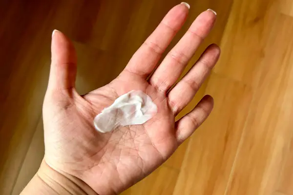 A person holds some Bounce Curl Moisture Balance Leave-In Conditioner in their hand