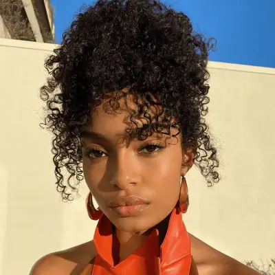 yara shahidi wearing a curly updo