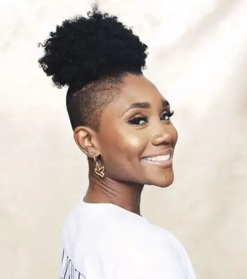 Woman with curly topknot mohawk hairstyle