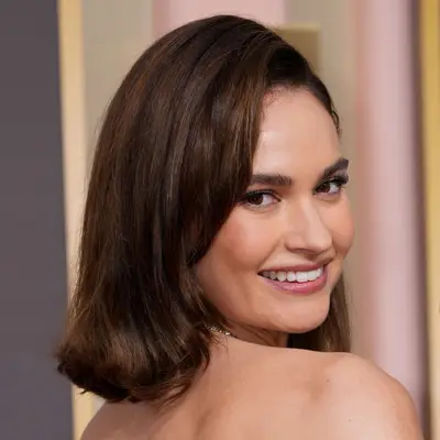 Lily James at the Golden Globes looks over her shoulder to pose with a modern but glam flippy bob and side part