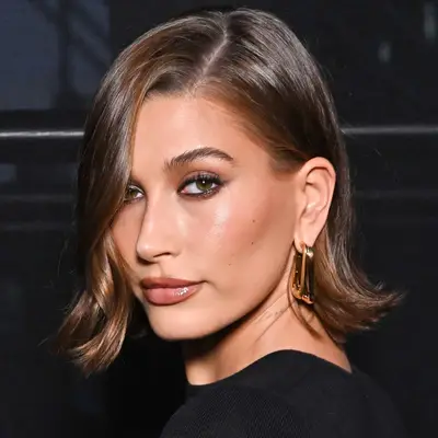 Hailey Bieber wears a flippy bob with a natural side parting while looking over her shoulder