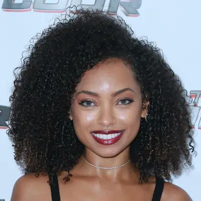 Logan Browning wears a curly Afro hairstyle