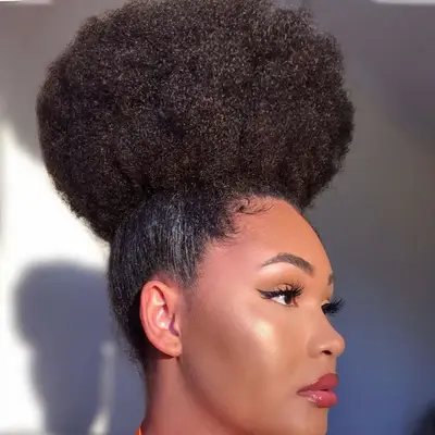 Woman wears an Afro hairstyle in a high puff
