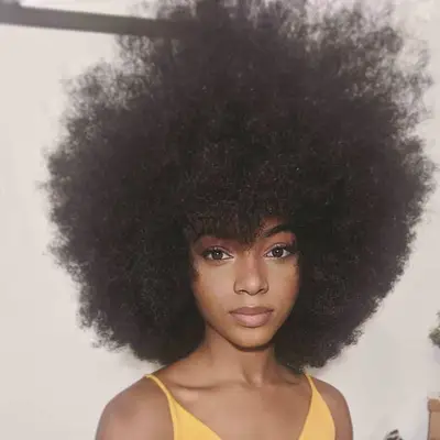 Woman wears an Afro hairstyle with bangs