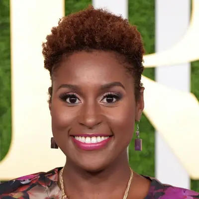 Issa Rae wears short copper natural curls and pink lipstick
