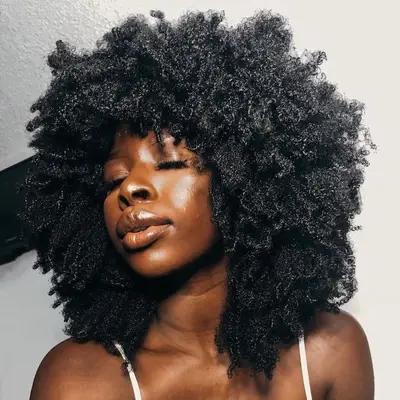 Woman with a voluminous, curly Afro hairstyle