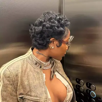 Jayda Cheaves looking away in elevator showing off fluffy curled short cut
