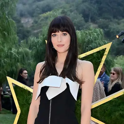 Close up of Dakota Johnson with a deep, rich hair color and curtain bangs