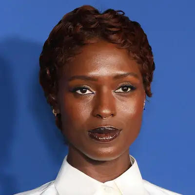Jodie Turner-Smith wears a wavy auburn pixie and glossed matching lip color