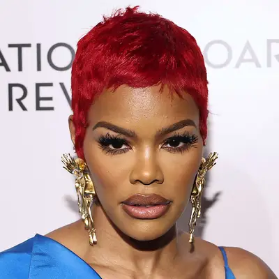 Teyana Taylor attends an event with large decorative earrings and a bright red pixie cut
